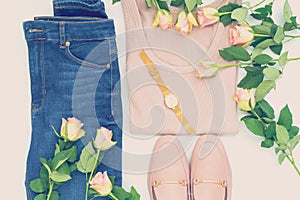 Flatlay of women`s stylish neutral outfit and roses on white bacground. Trendy clothes collage. Minimal and beauty blog