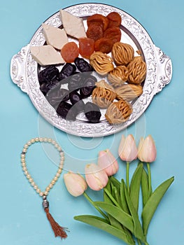 Flatley with rosaries, sweets, dates and tulips. The Concept Of Ramadan