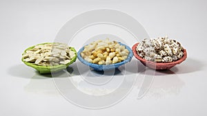 Flattened rice, puffed rice, and popped rice in color paper thonga bowl on white background studio shoot. local name chira, Muri,