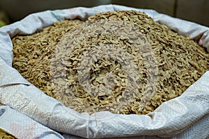 Flattened rice on a village market. Fresh brown flattened rice