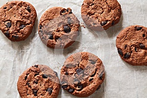 Flatview of chocolate cookies with chocolate chips and tea spoon