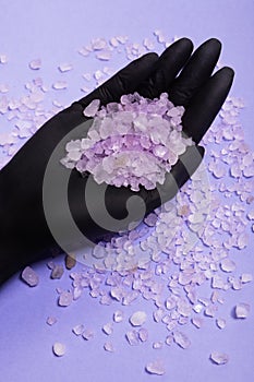Flavored, odorous salt for spa and bath. Salt on a female hand. Natural crystallized product from the sea