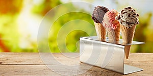 Flavors of ice cream in cones on an outdoor table