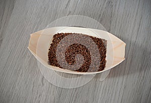 Flax seeds in a eco, wooden container  on wooden background