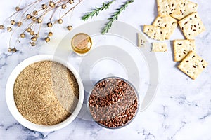 Flax seeds, flax flour, butter and crackers with sprouts and flax bolls on a light background