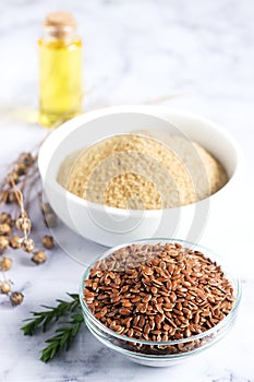 Flax seeds, flax flour, oil with sprouts and flax seed boxes on a light background