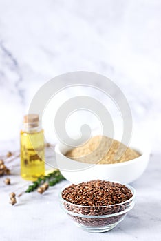 Flax seeds, flax flour, oil with sprouts and flax seed boxes on a light background
