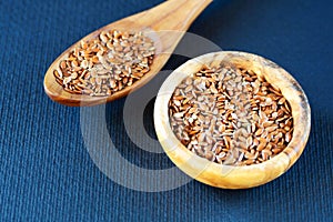 Flax seeds Linum usitatissimum are useful in a bowl of olive wood on flax. Product for beauty and health. Proper nutrition