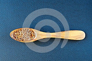 Flax seeds Linum usitatissimum are useful in a bowl of olive wood on flax. Product for beauty and health. Proper nutrition