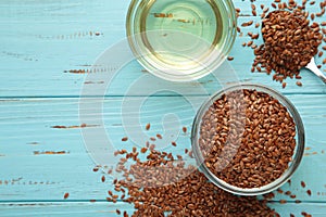 Flax seeds and oil in bottle on blue wooden background. Top wiev