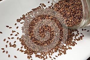 Flax seeds spilling out of container, close up