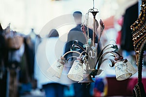 Flea market: Old fashioned lamp in the foreground, people in the blurry background