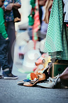 Flea market: shoes, dress and stuff in the foreground, people in the blurry background