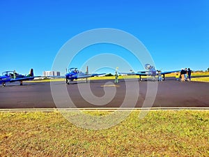 Fleet of aircraft lined up side by side on a tarmac runway, ready for takeoff