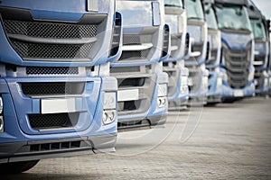 Fleet of commercial lorry trucks in row. Logistics and transportation service