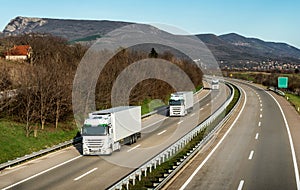 Fleet or convoy of trucks on highway photo
