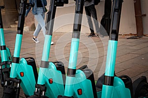 A fleet of dockless electric scooters for rent, lined up on a European city street, offering an eco-friendly, convenient & modern photo