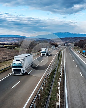 Fleet of White Trucks - a convoy in line at a rural countryside highway