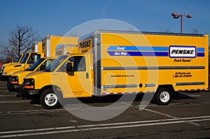 A fleet of yellow Penske rental trucks