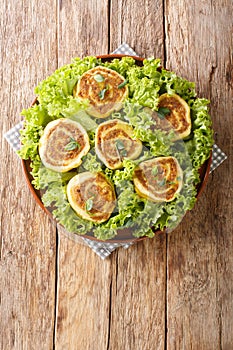 Fleischschnacka snails of meat, this French recipe from the Alsace serve with green salad close-up in a plate. Vertical top view