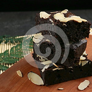 Fleshly baked almond brownies on wooden background