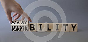 Flexibility and Adaptability symbol. Businessman hand Turnes cubes and changes word Adaptability to Flexibility. Beautiful grey