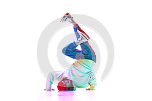 Flexible, artistic young man, hip hop, breakdancer in motion, performing isolated over white studio background in neon