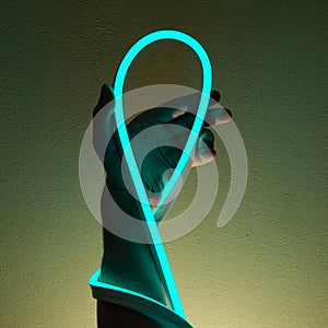 Flexible blue led tape neon in hand on black background