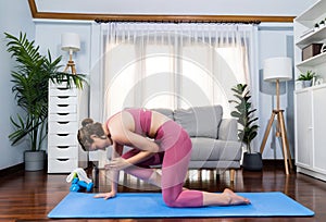 Flexible and dexterity woman in sportswear doing reverse gaiety yoga position