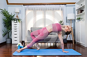 Flexible and dexterity woman in sportswear doing reverse gaiety yoga position