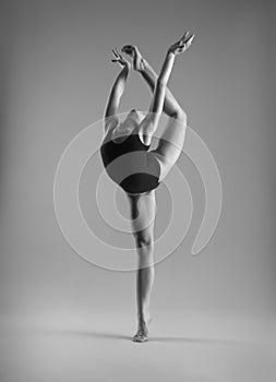 Flexible girl in a black swimsuit