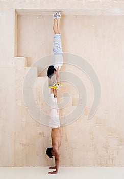 Flexible girl and man doing stretching and handstand in studio. Concept of individuality, creativity and self-confidence