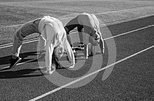 Flexible girls gymnasts stand in crab position on athletics track, flexibility