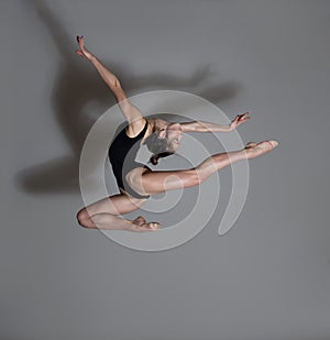Flexible gymnast. Girl makes an expressive jump