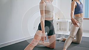 Flexible ladies bending body foot indoors. Slim girls stretching waist muscles