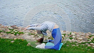 Flexible lady with dark ponytail performs bridge pose