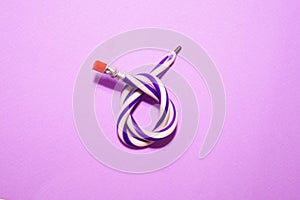 Flexible pencil on a purple background. The curved pencil is two-tone. Purple and white.