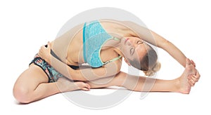 Flexible slim woman making yoga Bend to right leg with rotation