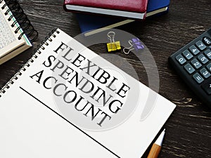 Flexible Spending Account FSA and notebooks on wooden surface