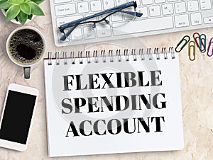 Flexible Spending Account FSA sign on notebook with keyboard and coffee,smartphone,glasses on office desk