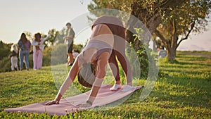 Flexible woman practicing yoga position on rubber mat. Lady raising up one leg