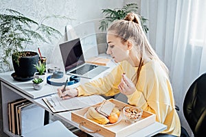 Flexible working, flexible work. Young woman freelancer working at home office with laptop and documents. Flexible work