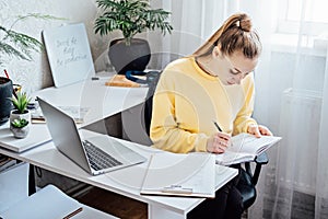 Flexible working, flexible work. Young woman freelancer working at home office with laptop and documents. Flexible work