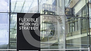 Flexible Working Strategy sign in front of a modern office building