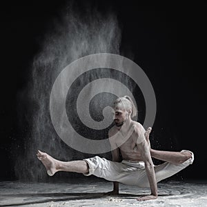 Flexible yoga man doing hand balance asana brahmachariasana.