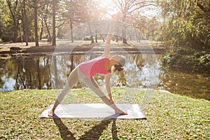Flexible Young Woman Performing Yoga Exercise In Triangle Pose