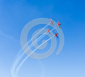 A flight of aircraft performs aerobatics in the blue sky photo