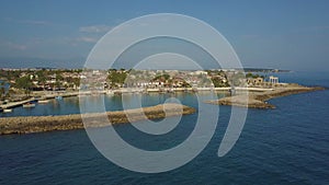 Flight around the peninsula with moored boats and low buildings. Top view of the sea and the coast.