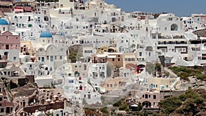 Flight around of three blue domes church in Oia town on Santorini island, Greece