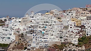 Flight around of three blue domes church in Oia town on Santorini island, Greece